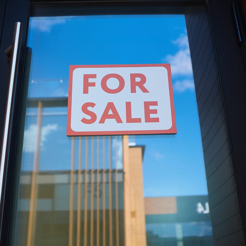 For Sale sign on a glass door